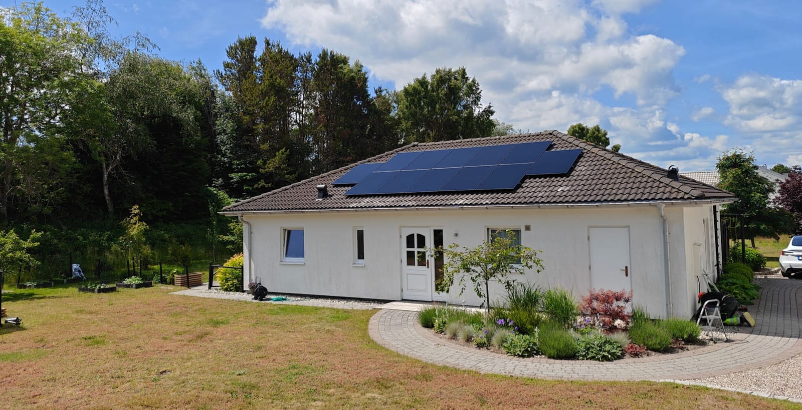 Solceller på tegeltak på vit villa i Nybrostrand öster om Ystad